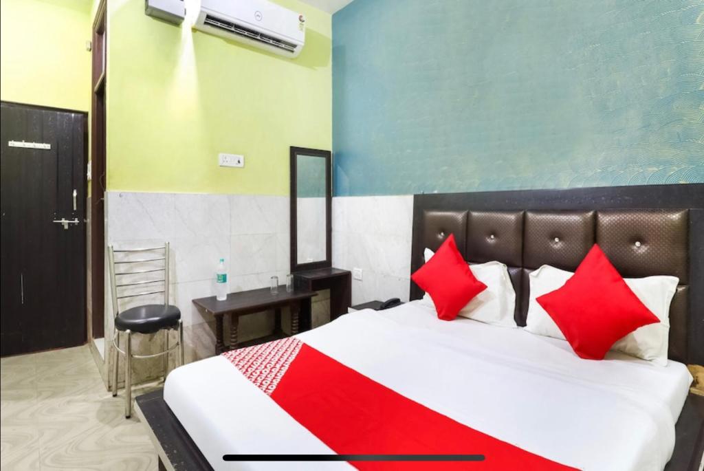 a bedroom with a large bed with red pillows at Hotel Park View in Kānpur