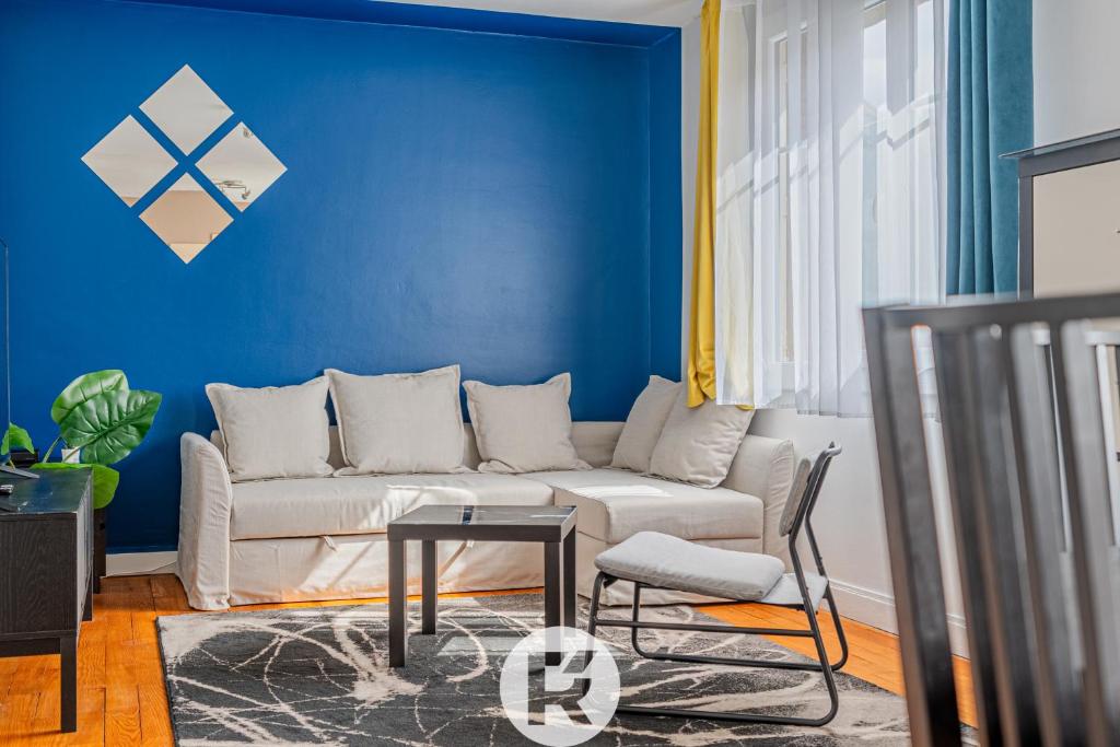 uma sala de estar com um sofá e uma parede azul em R 'Apparts T3 Isère Dreams em Grenoble
