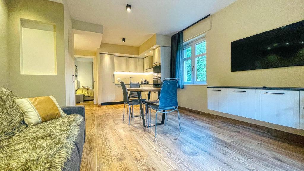 een woonkamer met een bank en een tafel met stoelen bij Appartamento Torino 61 - Affitti Brevi Italia in Oulx