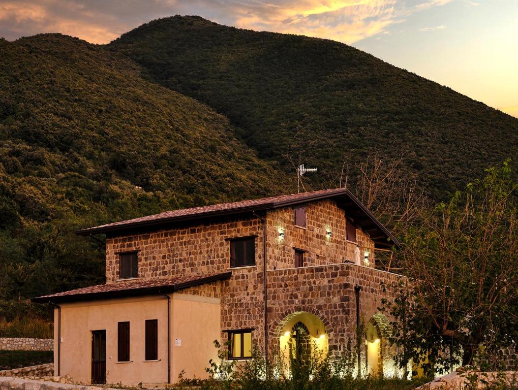 un bâtiment en briques avec une montagne en arrière-plan dans l'établissement Agriturismo ARCE di Monte Acero, à Faicchio