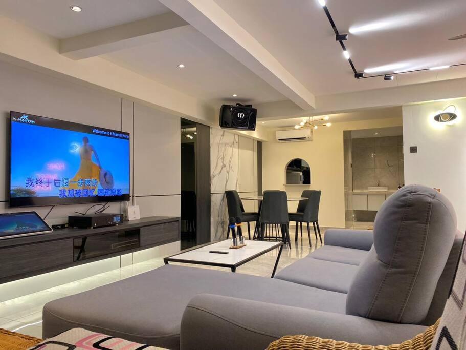 a living room with a couch and a flat screen tv at Brand New Premium House & Karaoke @BM Near Iconcity in Bukit Mertajam
