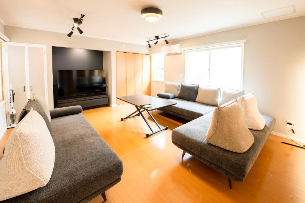 a living room with two couches and a television at Villa Futaba若松町 in Hakodate