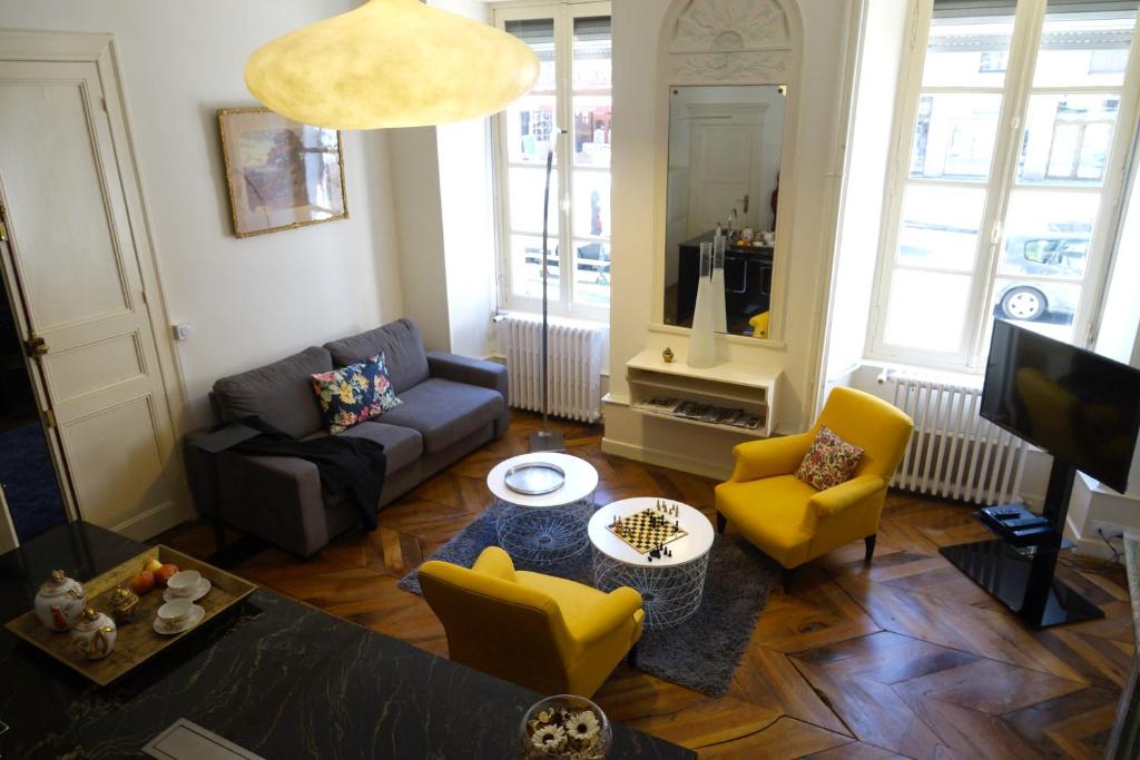 a living room with a couch and yellow chairs at Maison Eugénie in Luchon