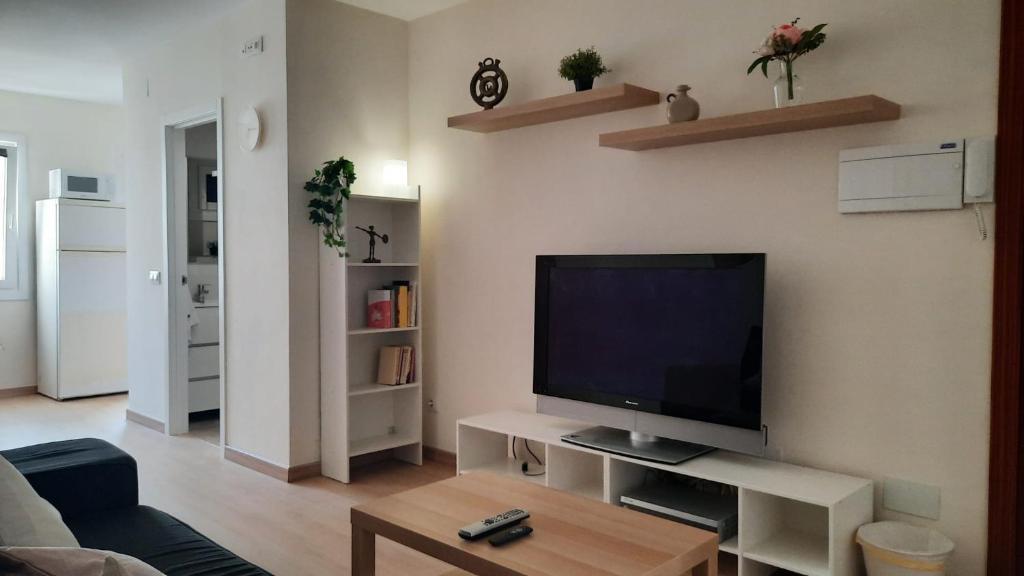 sala de estar con TV de pantalla plana en la pared en VibesCoruña-Adelaida 41 en A Coruña