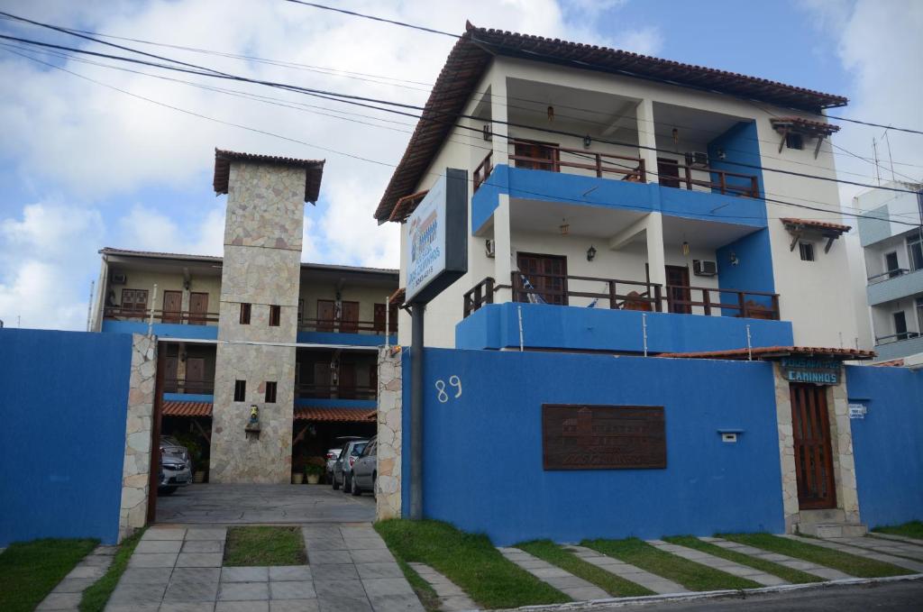 a building with a blue fence in front of it at Pousada dos Caminhos in Aracaju