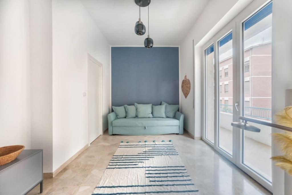 sala de estar con sofá azul y ventana en Blue Horizon, en Pescara