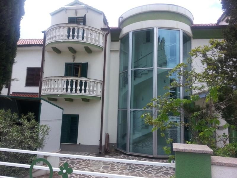 a house with a large glass door and a balcony at Vila Smirna in Sveti Filip i Jakov