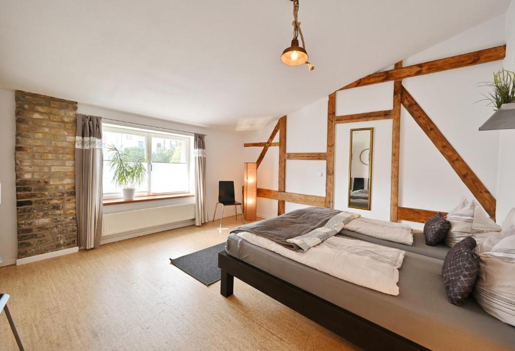 a bedroom with a large bed and a large window at Zur Alten Schmiede in Stralsund