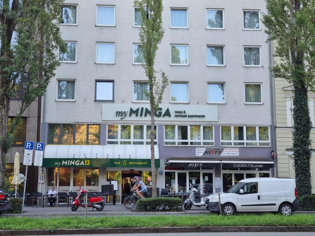 myMINGA13 - Hotel & serviced Apartments في ميونخ: سيارة فان بيضاء متوقفة أمام مبنى