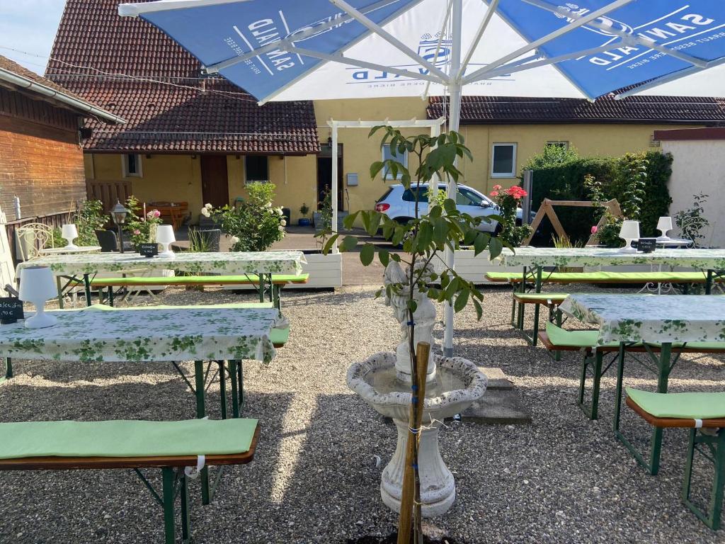 um grupo de mesas e cadeiras com guarda-sol em Gasthaus Zur Rose em Aalen