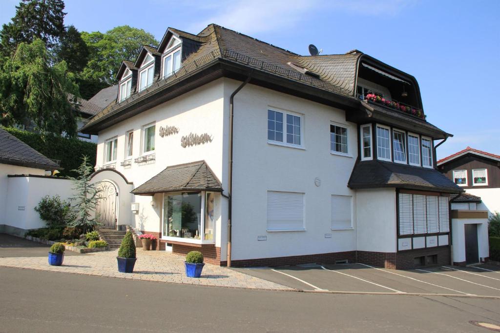 een wit huis met een zwart dak bij Ferienwohnung Stölben in Daun