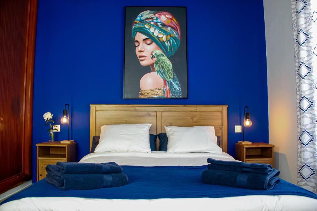 a blue bedroom with a bed with a painting on the wall at Malvasía House in Costa Teguise
