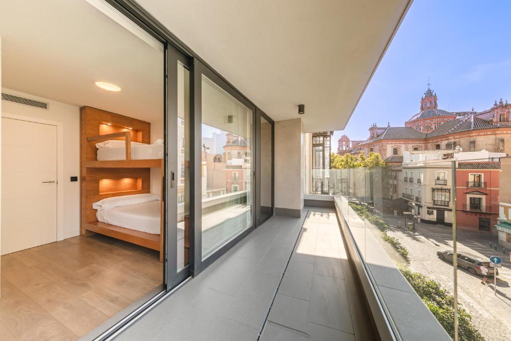 a bedroom with sliding glass doors and a bed on a balcony at Apartamento Sevilla Centro in Seville