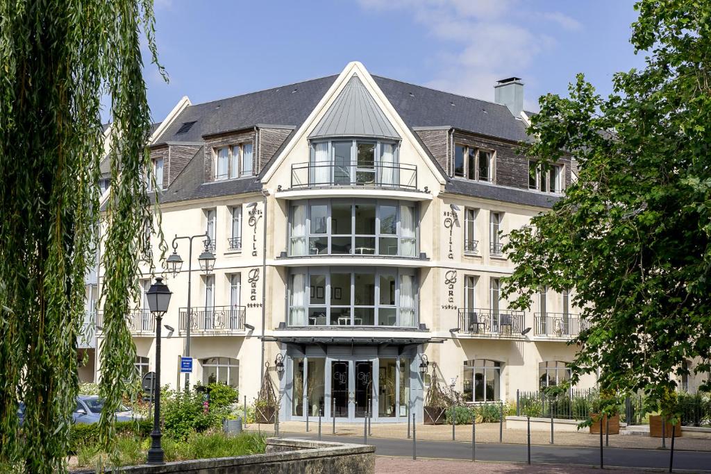 een groot wit gebouw met veel ramen bij Villa Lara Hotel in Bayeux