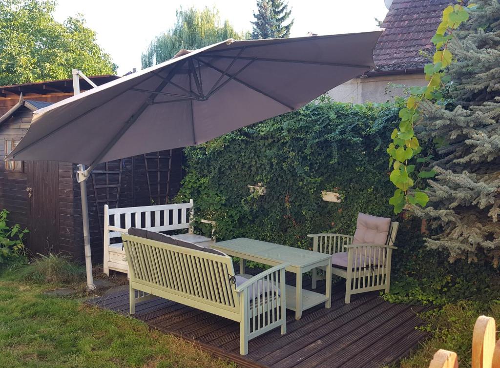 a table and two chairs and an umbrella on a deck at Mieszkanie z ogródkiem in Wrocław