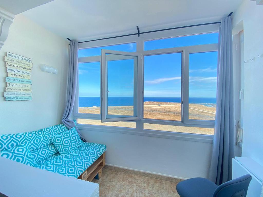 een kamer met een raam met uitzicht op de oceaan bij Lightbooking El Burrero in Ingenio