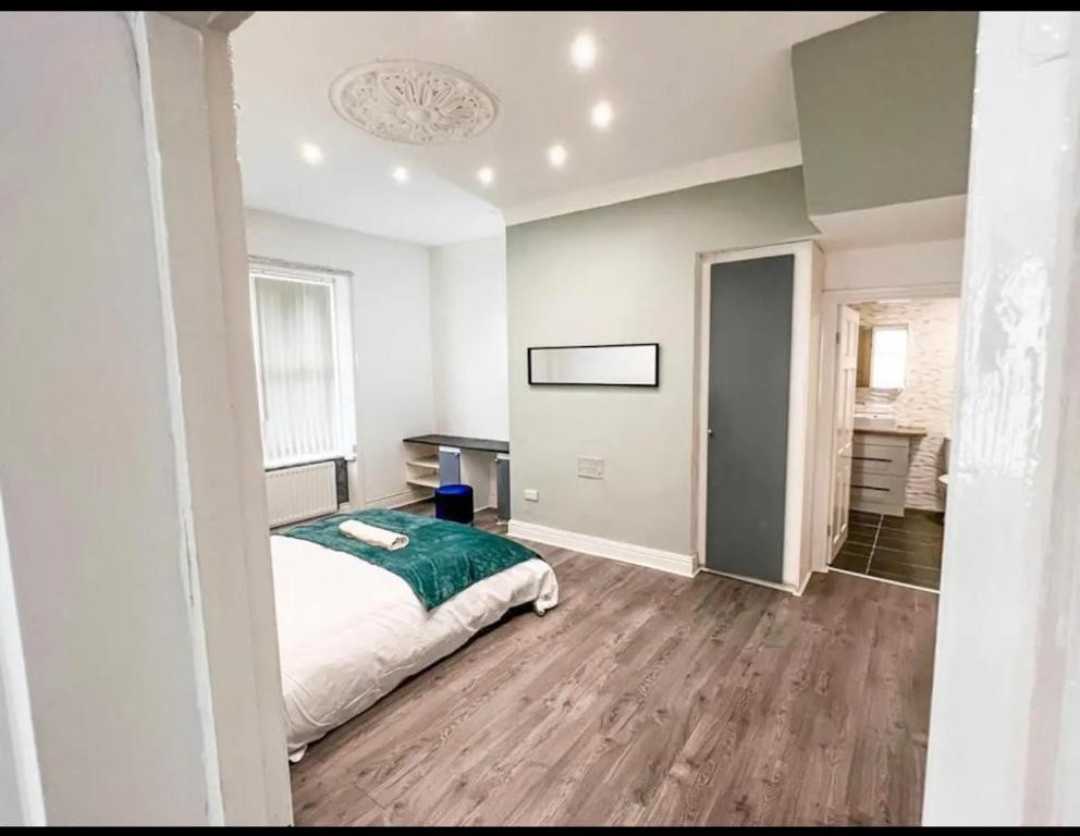 ein Schlafzimmer mit einem Bett mit einer grünen Decke in der Unterkunft Lovely 1-bedroom apartment, free street parking in Elswick