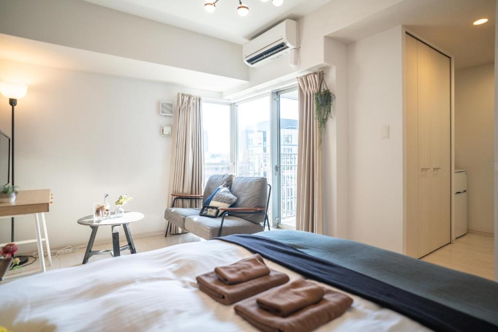 大阪市にあるLite House Dotonboriのベッドルーム1室(ベッド1台、椅子、窓付)