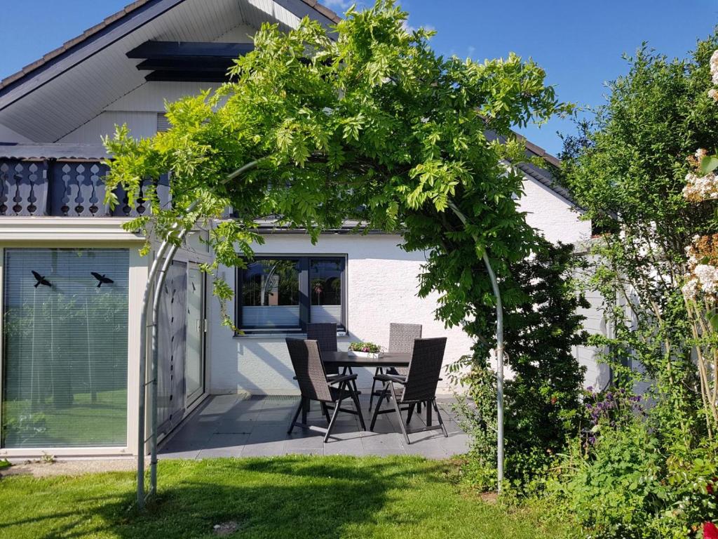 een patio met een tafel en stoelen in een tuin bij Ferienwohnungen Lilie Und Dahlie in Münsingen