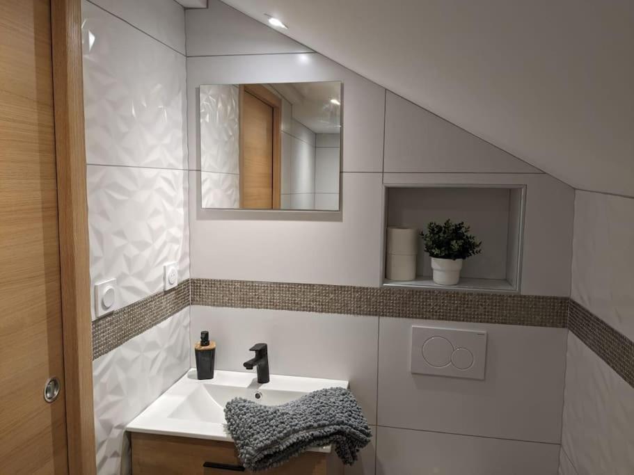 a bathroom with a sink and a mirror at Magnifique appartement entièrement rénové au pied des pistes in Métabief