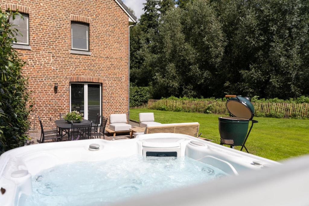 a hot tub in the backyard of a house at Hof de Draeck Apart in Voeren