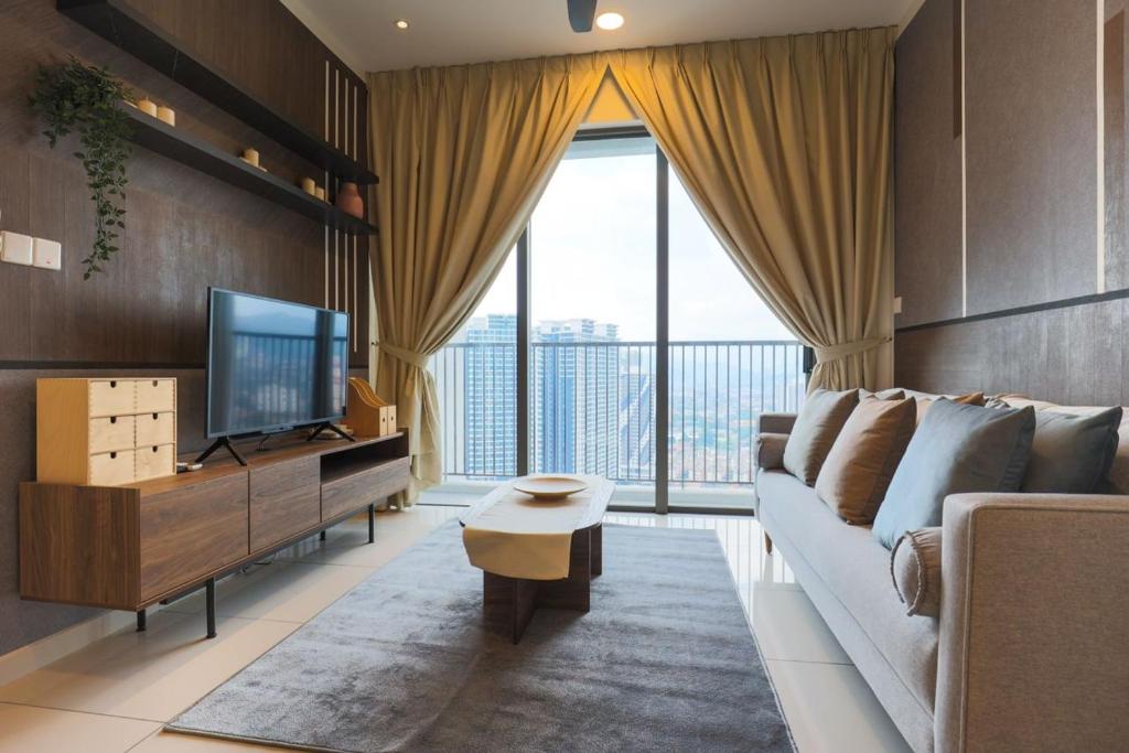 ein Wohnzimmer mit einem Sofa und einem TV in der Unterkunft 15 min to KL Pavillion & Beautiful Scenery By Nexx Field in Kuala Lumpur