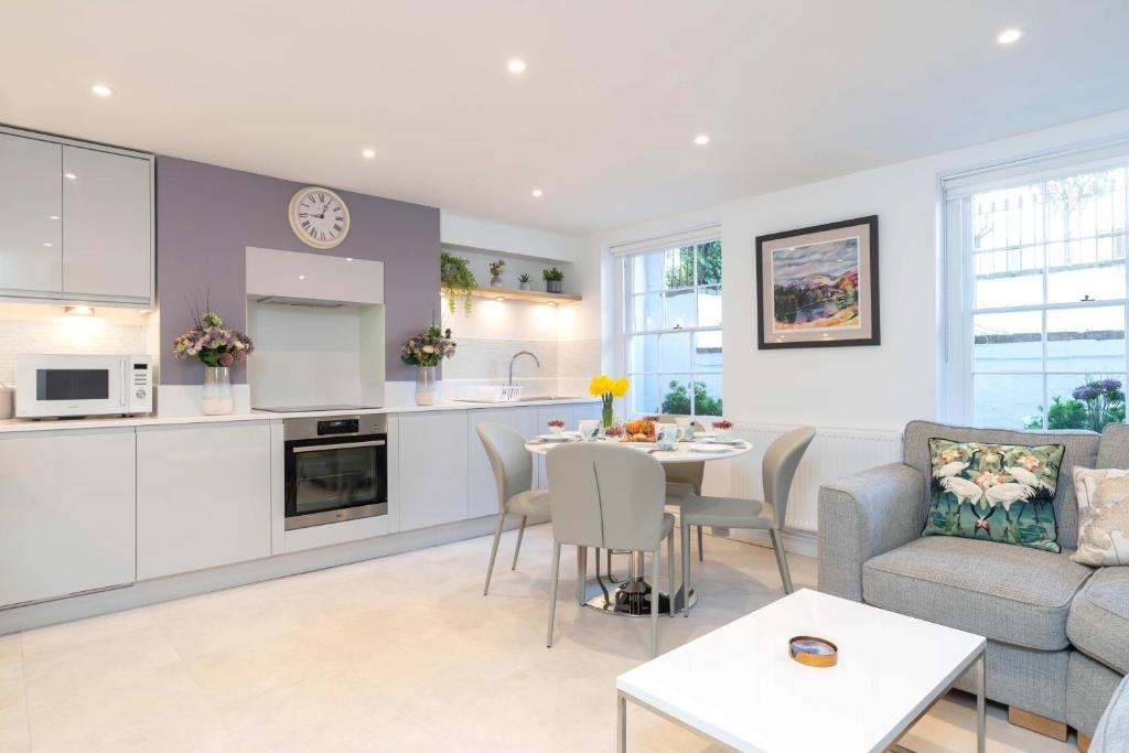 Hotel Stunning 2 Bed Basement Flat in the Heart of Cheltenham!, a kitchen and living room with a couch and a table at Stunning 2 Bed Basement Flat in the Heart of Cheltenham! in Cheltenham
