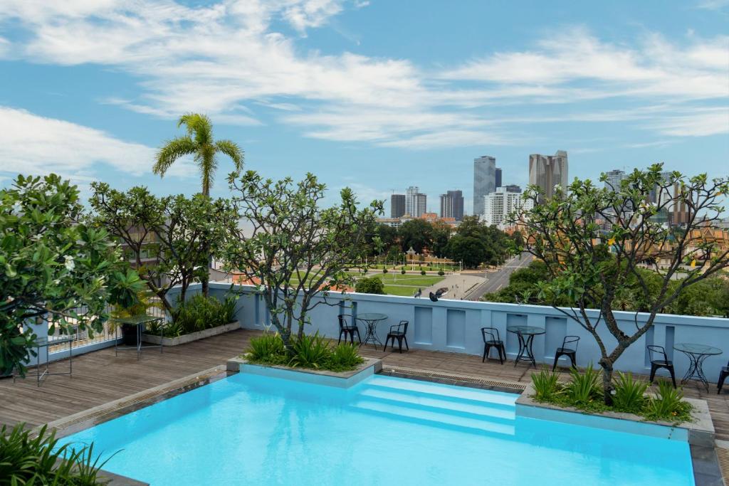 a swimming pool on the roof of a building with a city skyline at The Frangipani Royal Palace Hotel in Phnom Penh