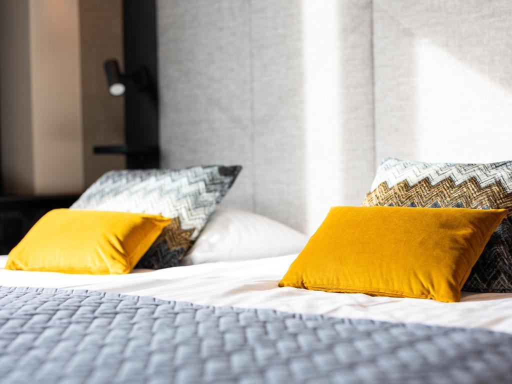 a bed with two yellow pillows on it at Santa's Hotel Santa Claus in Rovaniemi