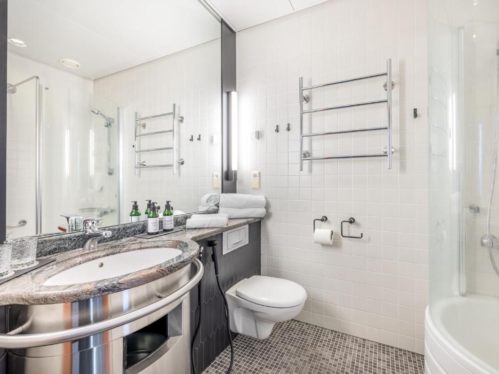 a white bathroom with a toilet and a sink at Santa's Hotel Santa Claus in Rovaniemi