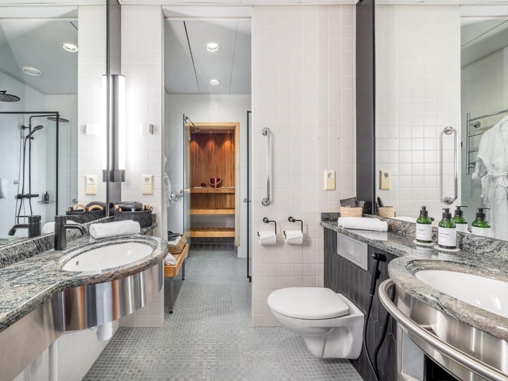 a bathroom with two sinks and a toilet at Santa's Hotel Santa Claus in Rovaniemi