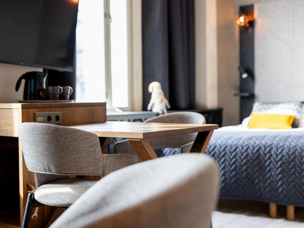 a room with a table and chairs and a bed at Santa's Hotel Santa Claus in Rovaniemi