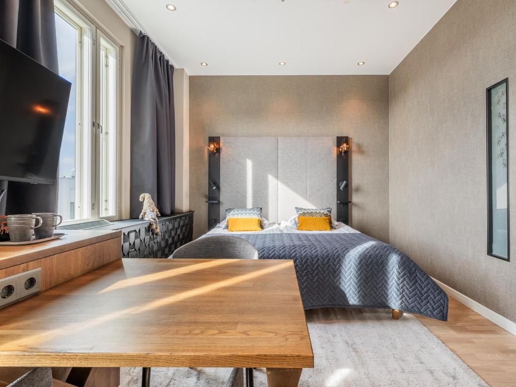 a bedroom with a bed and a wooden table at Santa's Hotel Santa Claus in Rovaniemi