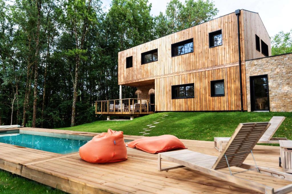 ein Haus mit einem Pool und einer Terrasse mit einem Haus in der Unterkunft Dans les Arbres in Lanta