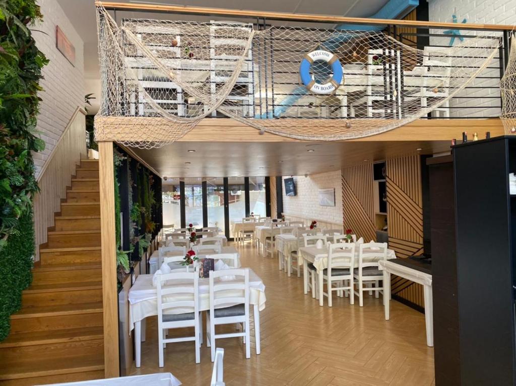 a dining room with white tables and white chairs at Sunrise Tirana Apartament's in Tirana