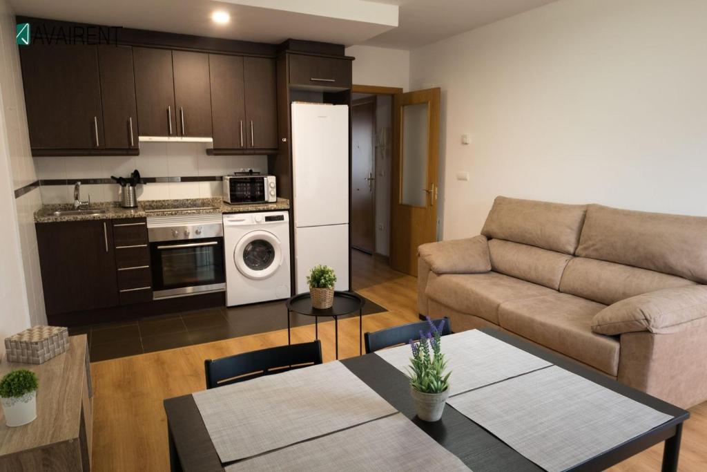 a kitchen and living room with a couch and a table at El Serrablo AVAIRENT Sabiñánigo in Sabiñánigo
