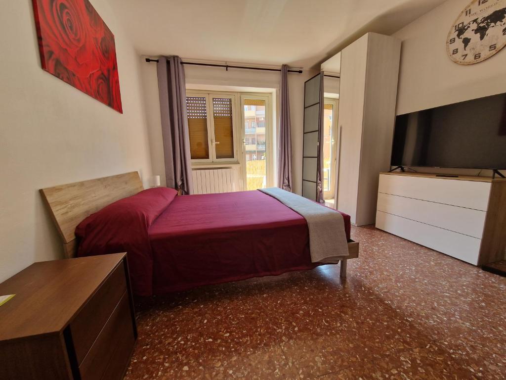 a bedroom with a red bed and a television at CorneliaGuestHouse in Rome