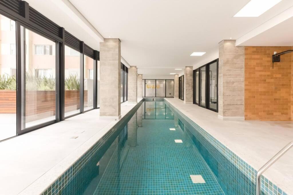una piscina con azulejos verdes en un edificio en Studio Batel en Curitiba
