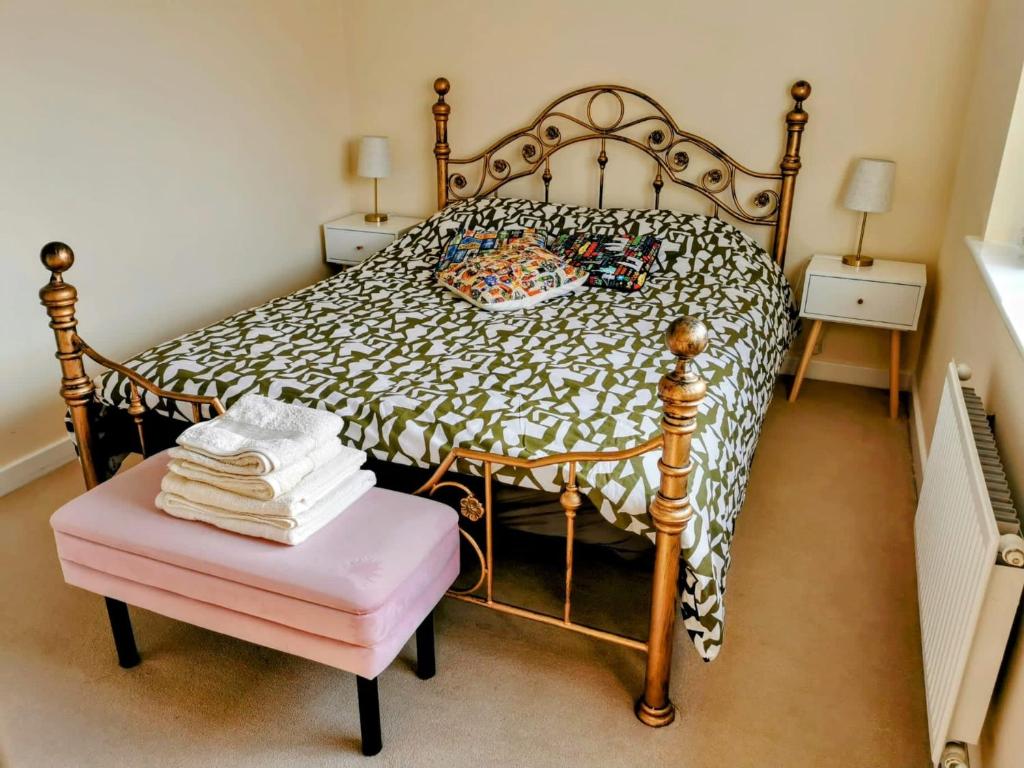 a bedroom with a bed and a pink stool at House with Breath of Fresh Air in Bloxwich