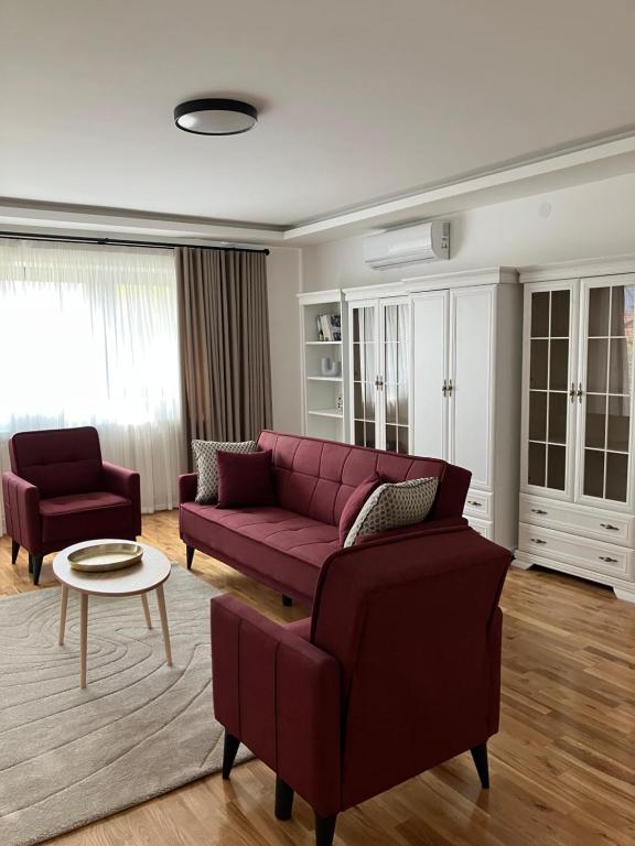 a living room with a red couch and a table at VILA SLAVA in Vrnjačka Banja