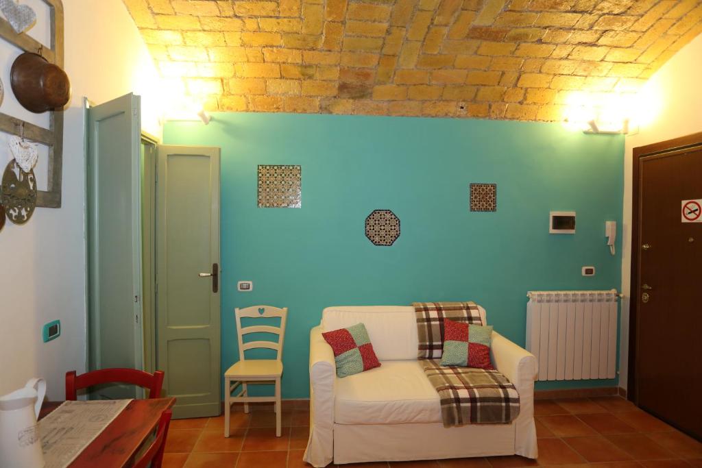ローマにあるIl Grottinoの白い椅子と青い壁のリビングルーム