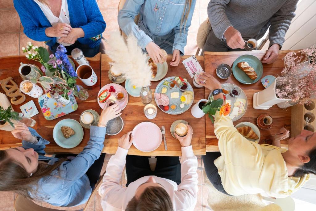 een groep mensen die rond een tafel eten bij Hotel 'Das Strandhaus' in Sankt Peter-Ording