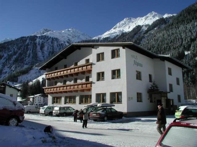 カウナータールにあるHaus Alpinaの雪に車を停めた大きな建物