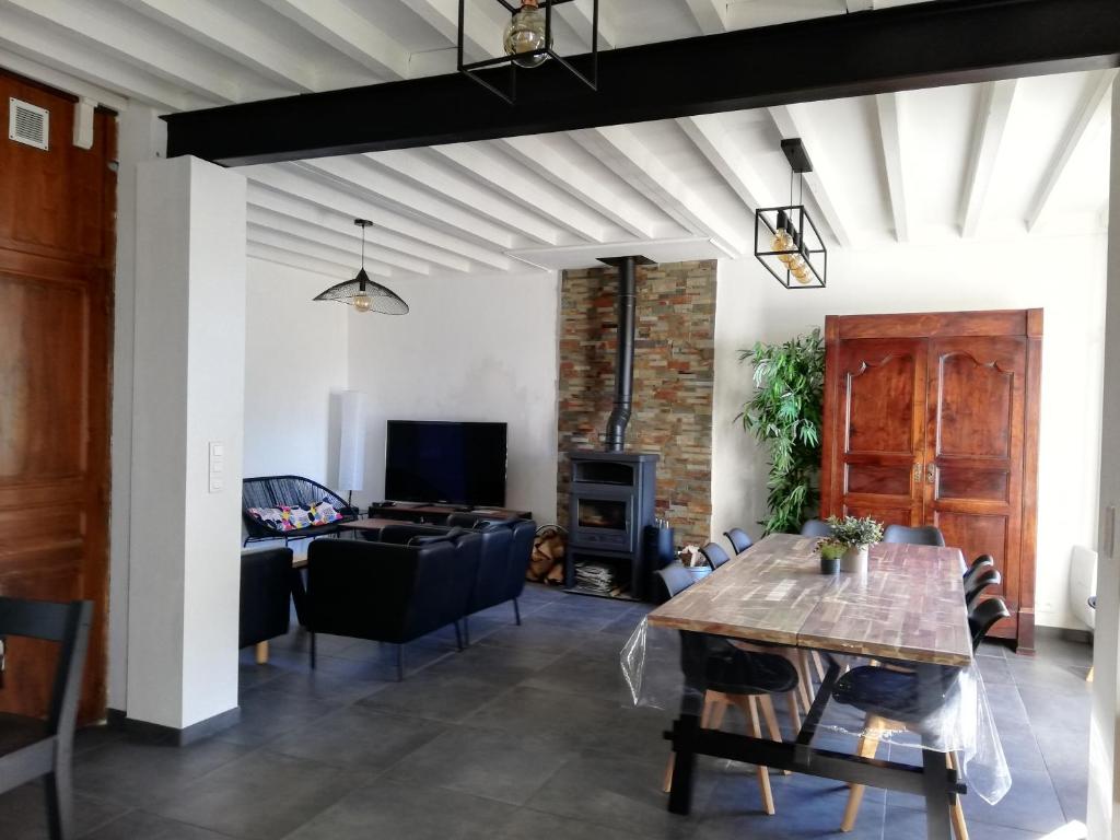 ein Wohnzimmer mit einem Tisch und einem Sofa in der Unterkunft Grand gîte au coeur d'un charmant village in Miglos