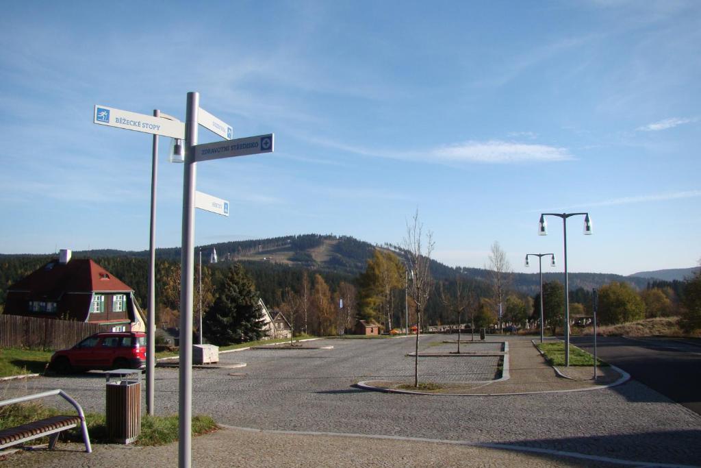 an empty parking lot with street signs on a pole at U Jindrů in Abertamy