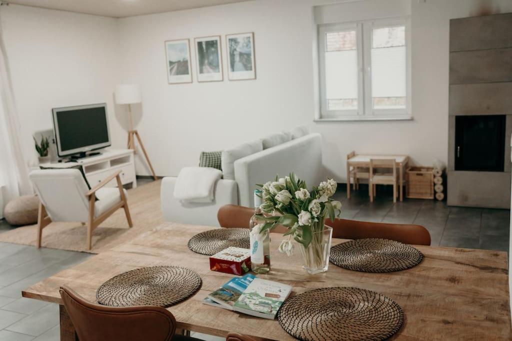 a living room with a table with flowers on it at Ferienhaus Stiefel in Schutterwald