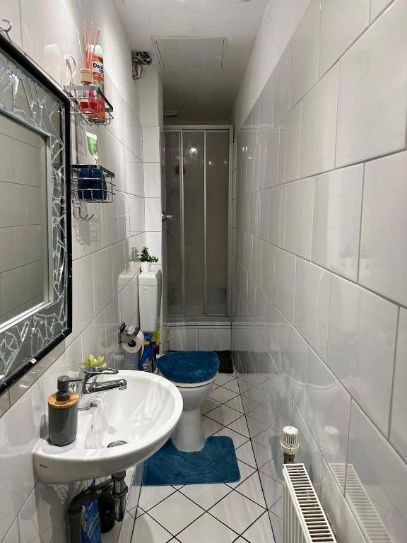 a white bathroom with a sink and a toilet at KH Apartment in Berlin