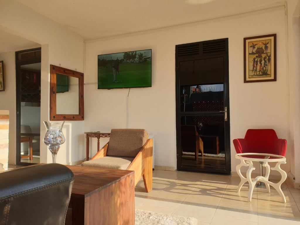 ein Wohnzimmer mit einem Sofa und einem Tisch in der Unterkunft Rosa negra kampala in Kigo