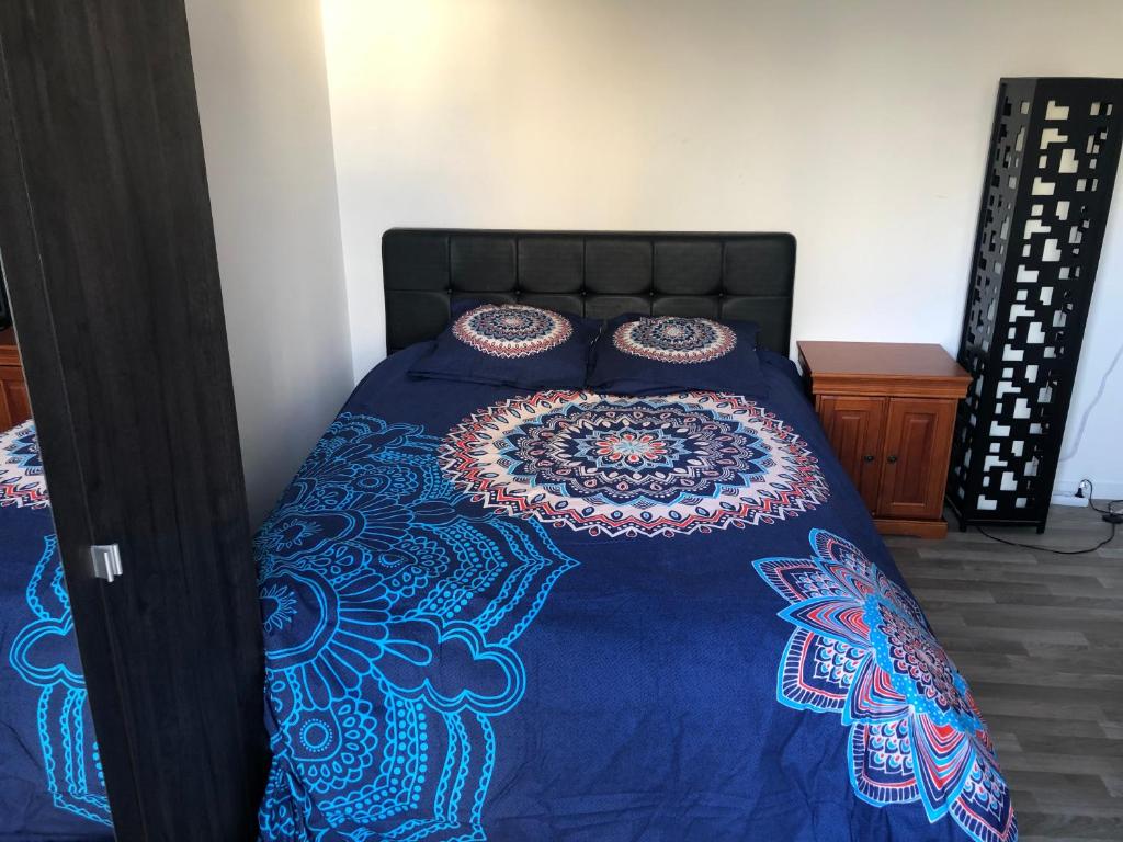 a bed with a blue blanket and pillows on it at Jolie chambre à Nanterre Préfecture proche La Défense Aréna Campus SNCF et Paris in Nanterre