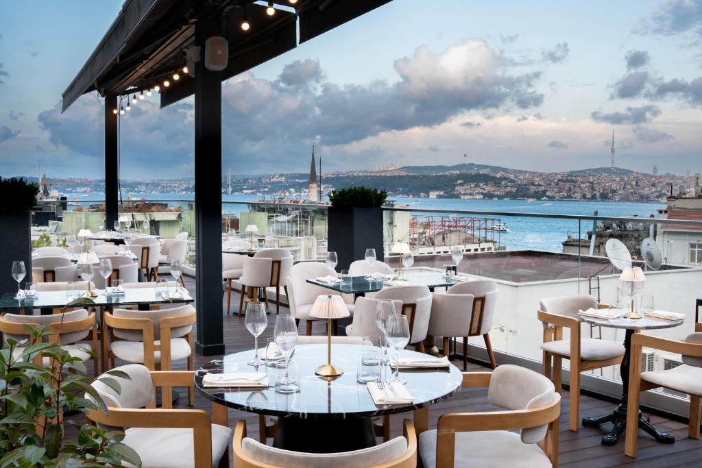 ein Restaurant mit Tischen und Stühlen und Stadtblick in der Unterkunft Loop Hotel Bosphorus İstanbul in Istanbul